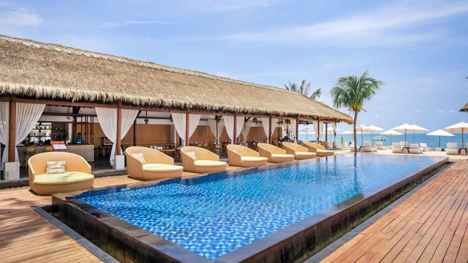 Luxurious infinity pool and thatched-roof restaurant overlooking the beach and ocean at Nusa Lembongan.