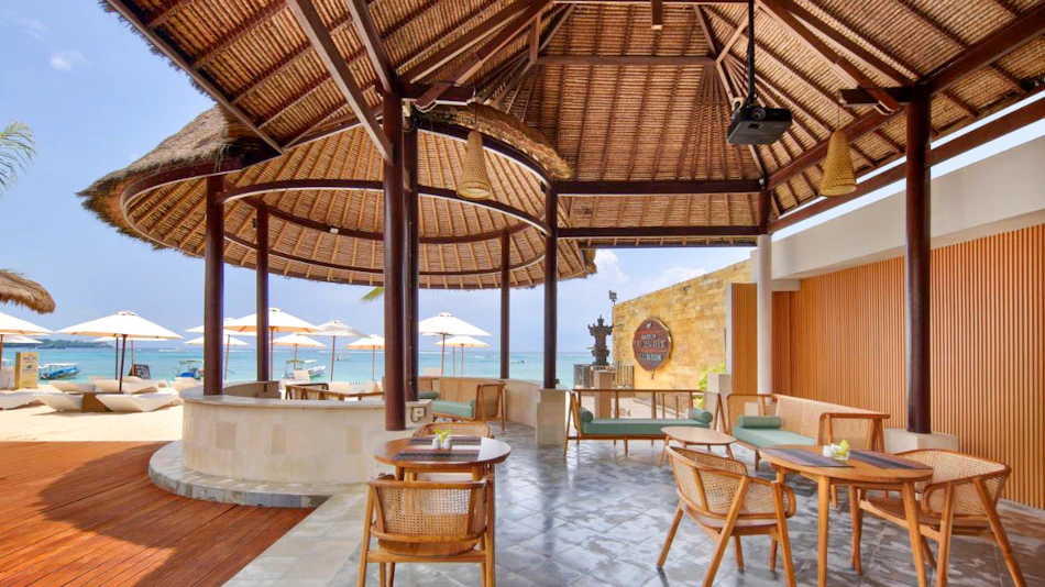 Lembongan Beach Club restaurant with thatched roofs, wicker furniture, and ocean views.