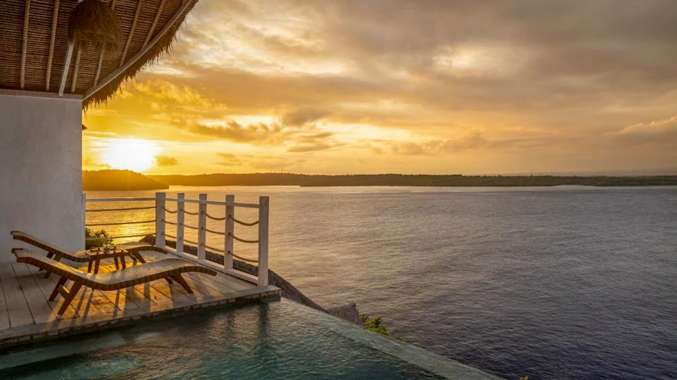 Romantic sunset over the ocean from a luxurious resort in Nusa Penida with an infinity pool.