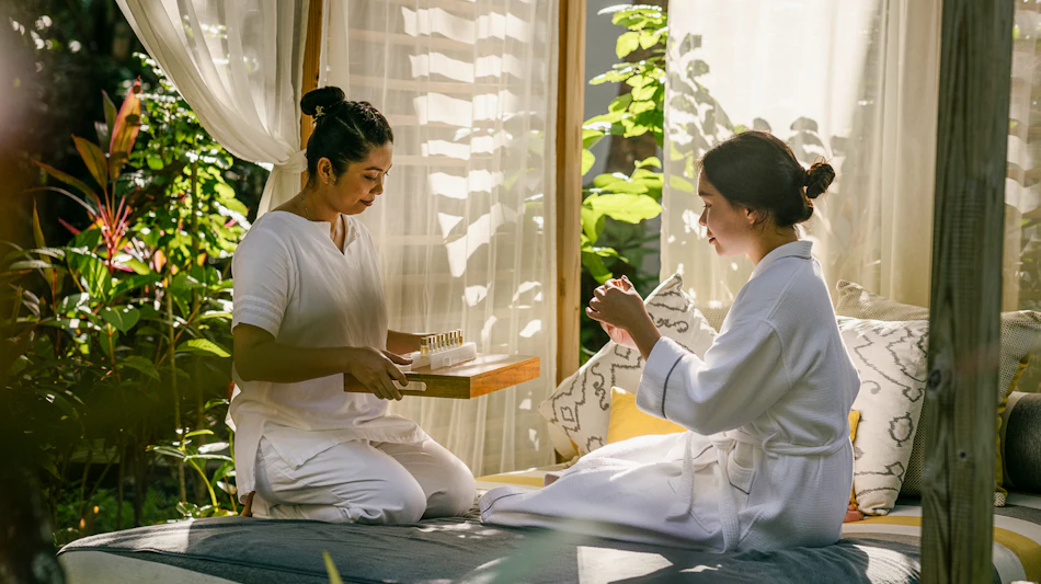 A therapist offers a luxurious outdoor spa treatment to a guest at Dhigali Resort.