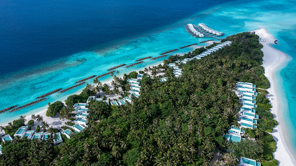 Stunning aerial view of Dhigali Maldives resort, showcasing lush island and luxury overwater villas.