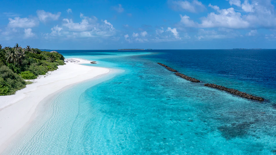 Aerial view of a pristine white sand beach and clear turquoise lagoon at Dhigali Maldives.