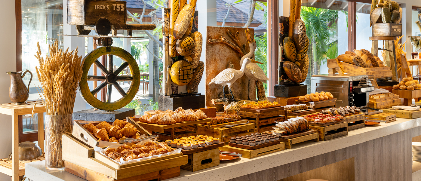 A luxurious breakfast buffet filled with pastries, bread, and desserts at Dhigali Maldives.