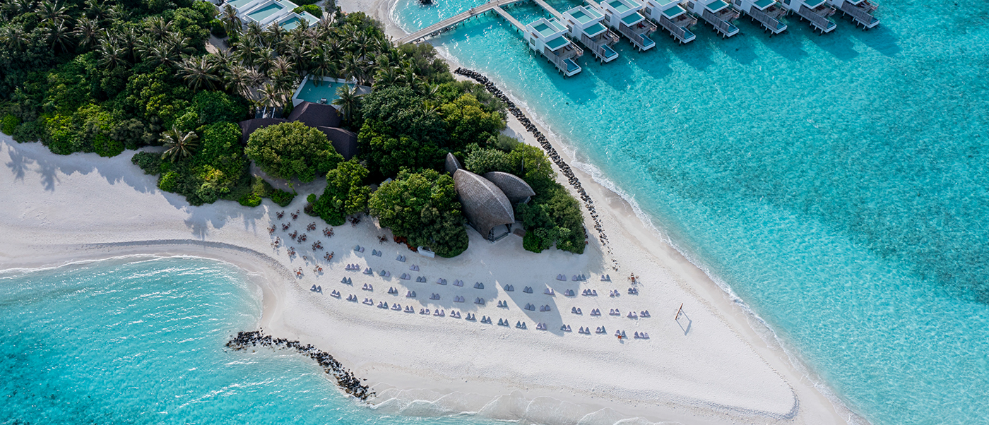 Stunning aerial view of Dhigali Maldives, featuring pristine white beaches and overwater villas.