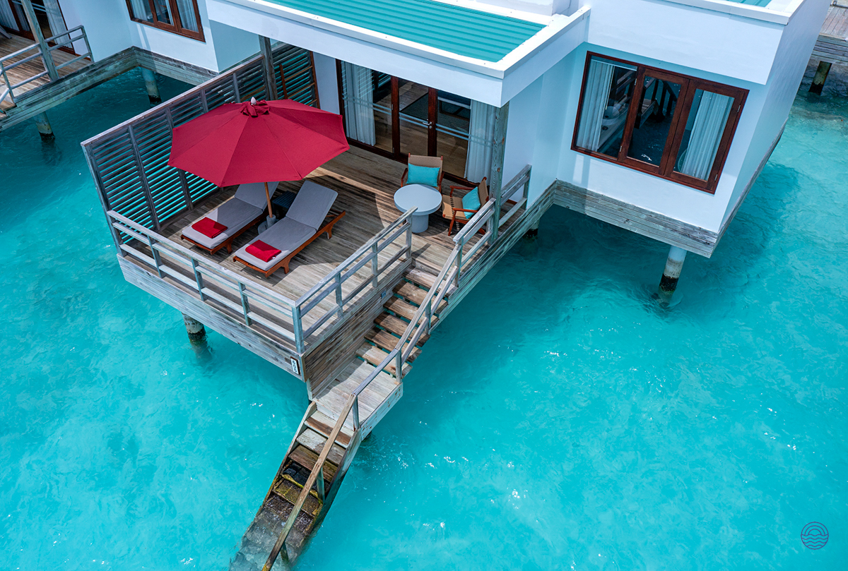 A luxurious water villa at Dhigali Maldives with a private deck over clear turquoise waters.