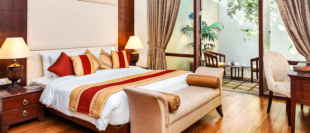 A luxurious hotel suite in Colombo with a large bed and a private outdoor patio.