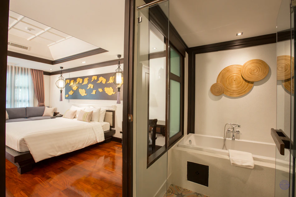 Luxurious bedroom and bathroom suite in a Thai resort, with a comfortable bed and soaking tub.