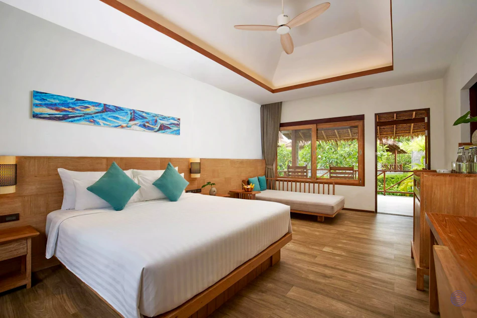 A bright and spacious resort room in Thailand with a king bed and tropical garden view.