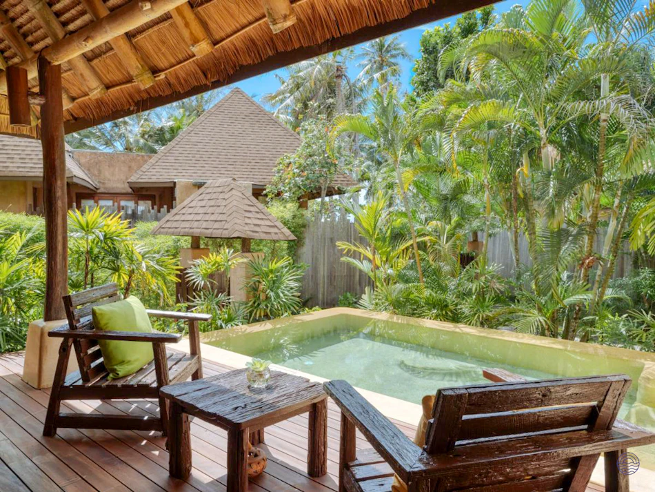 Inviting private pool villa with wooden deck, chairs, and lush tropical garden in Koh Kood.