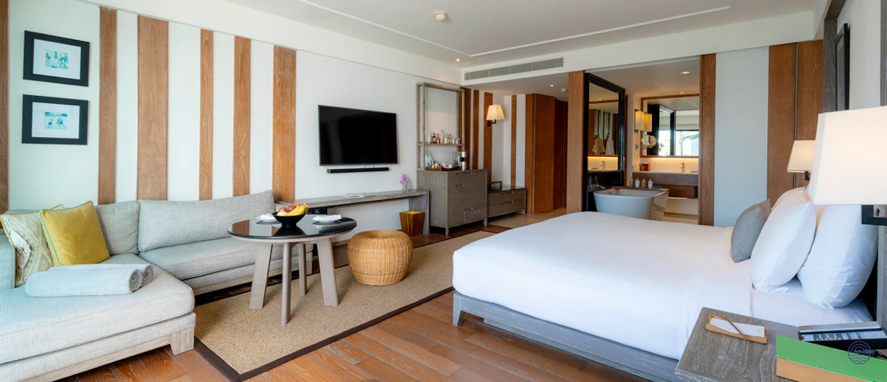 A luxurious resort room in Chiang Mai with a large bed and comfortable lounge area.