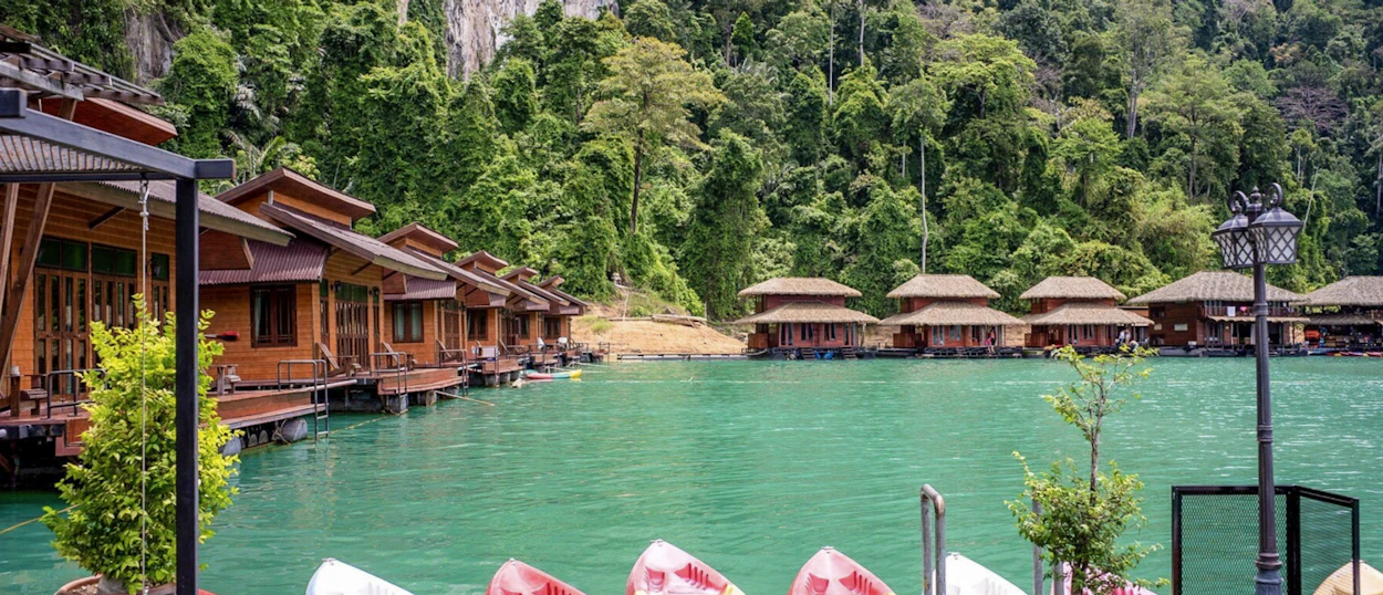 Tranquil floating bungalows on Chiewlan Lake, Khao Sok, nestled among lush green mountains.