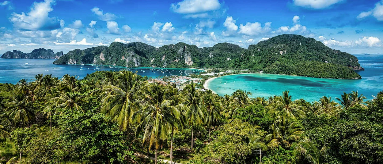 Panoramic view of Koh Phi Phi island, showing its iconic twin bays, green mountains, and blue ocean.