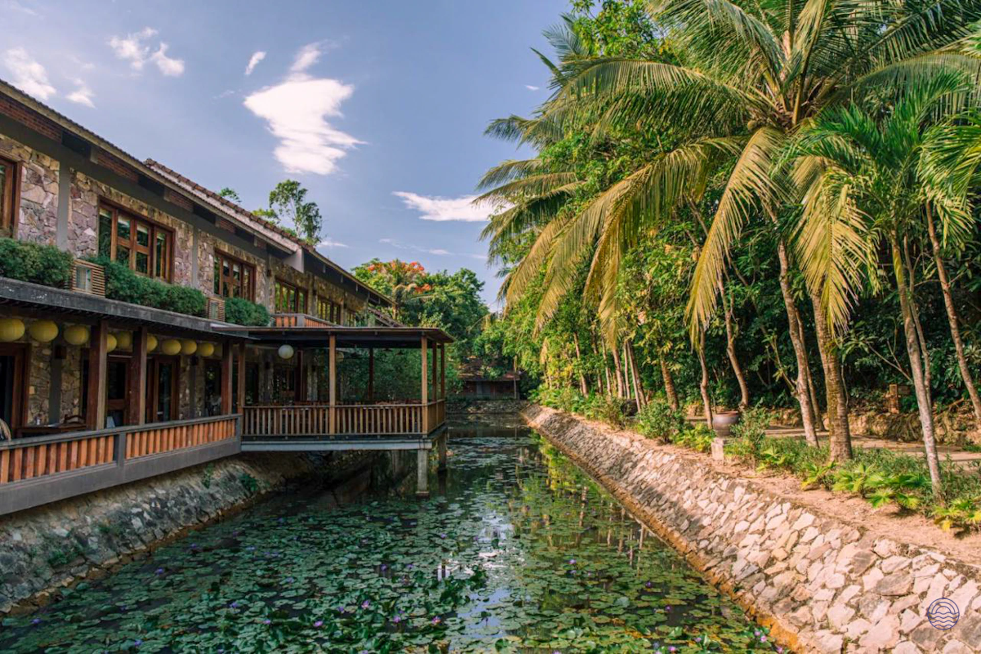 Pilgrimage Village Boutique Resort building in Hue, with balconies overlooking a lily-pad canal.