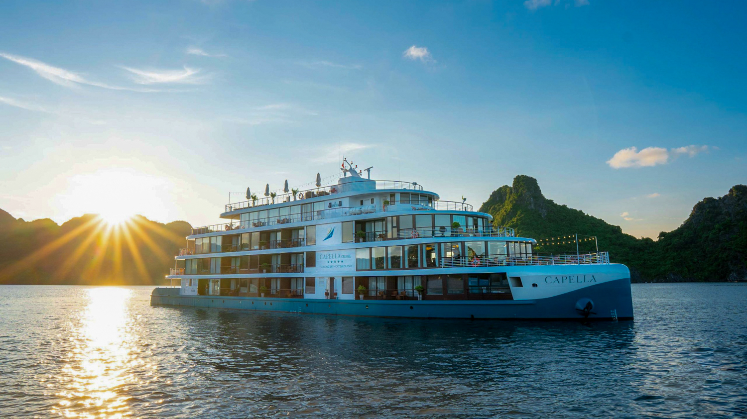 The Capella cruise ship at sunset among the limestone islands of Ha Long Bay, Vietnam.